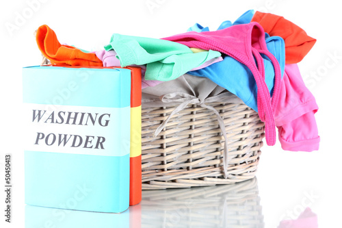 Clothes with washing powder in wooden basket isolated on white