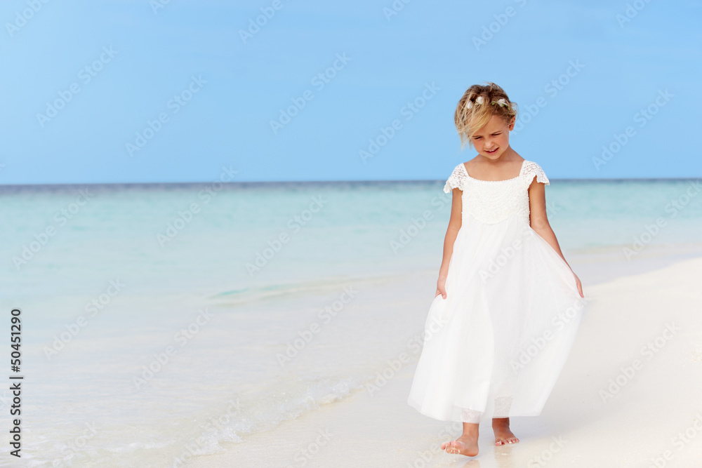 Young Girl In Bridesmaid Dress Walking On Beautiful Beach