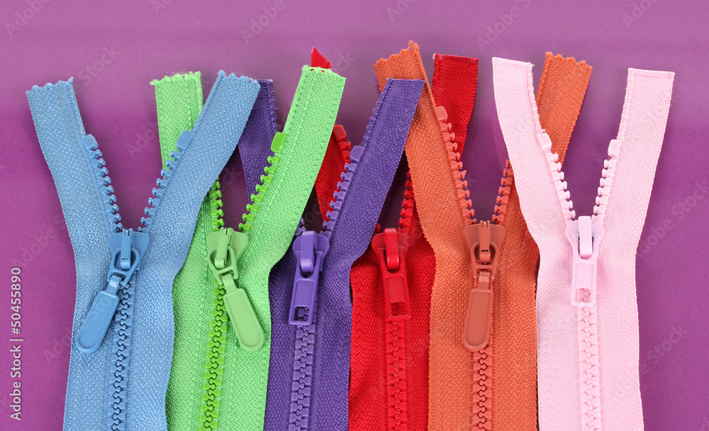 Multicolored zippers on purple background Multicolored zippers on purple background