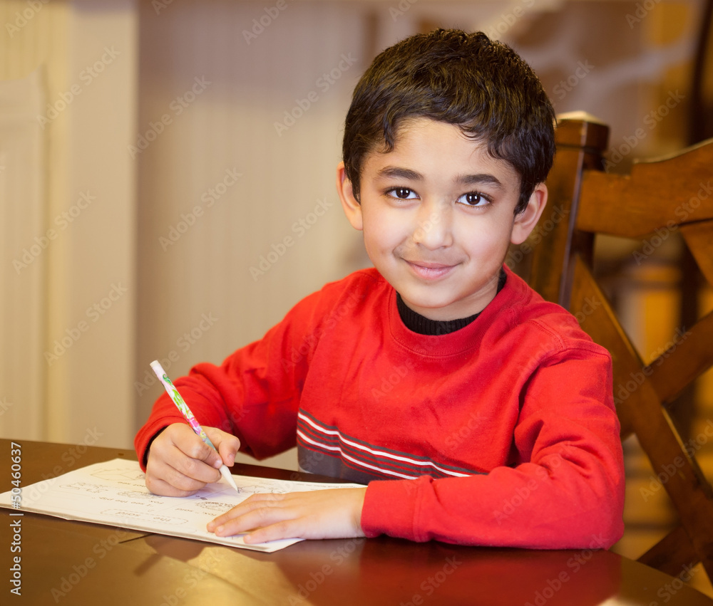 Little Boy Sitting at a Table and Doing His Homework Little Boy Sitting at a Table and Doing His Homework