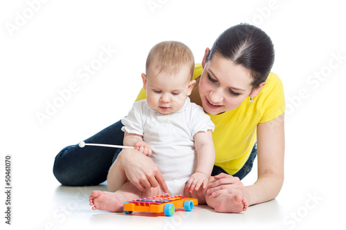 Mother and baby girl having fun with musical toy. Isolated on wh