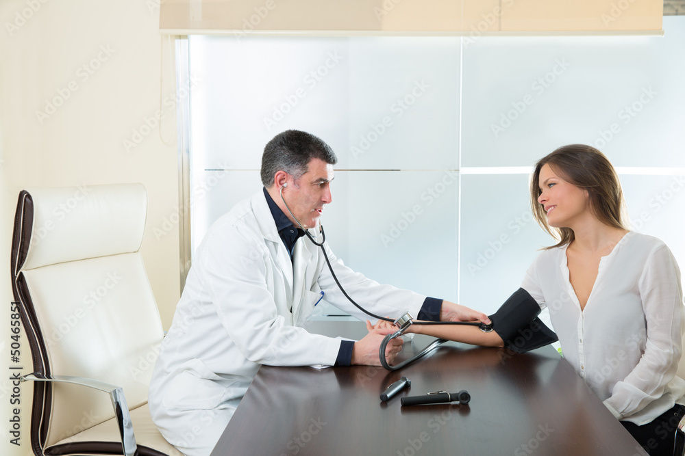 Doctor man checking blood pressure cuff on woman patient Doctor man checking blood pressure cuff on woman patient