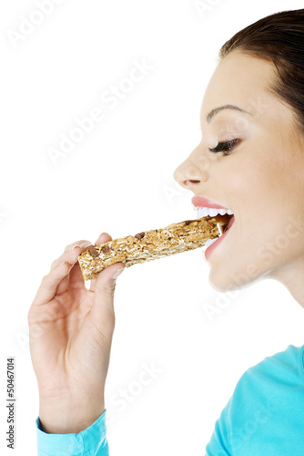 Young woman eating Cereal candy bar © Piotr Marcinski