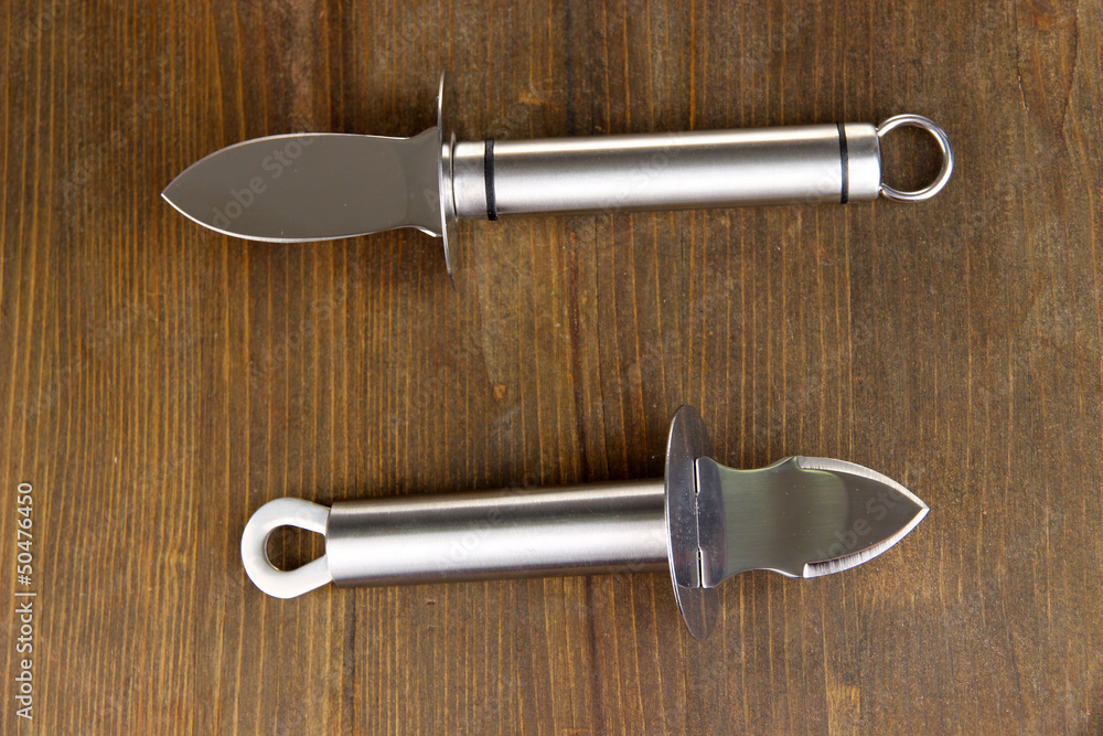 Knives for parmesan cheese and oysters, on wooden background Knives for parmesan cheese and oysters, on wooden background