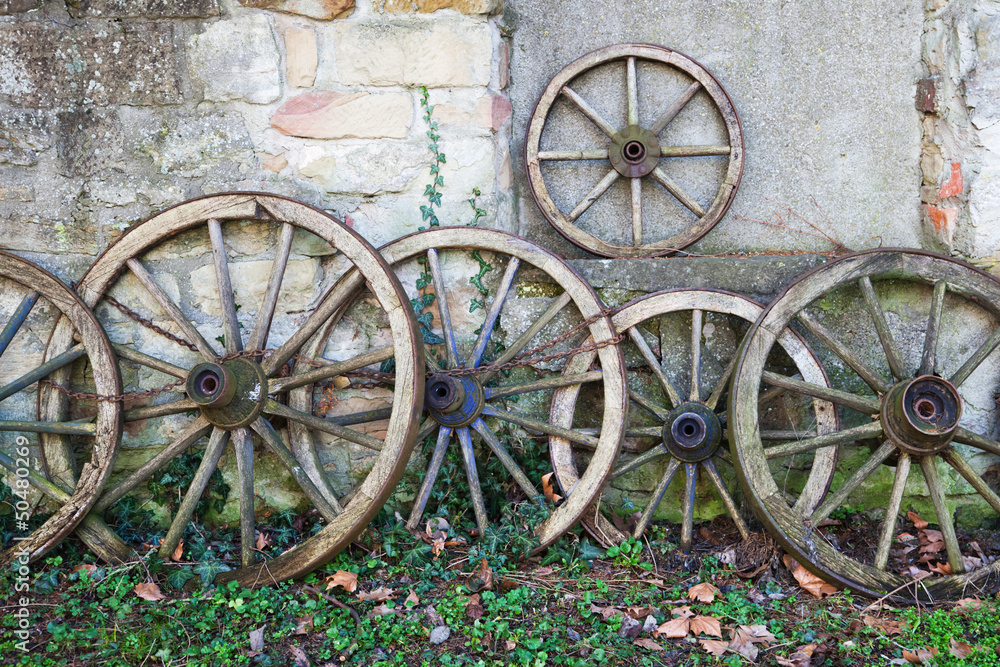 alte Wagenräder an einer Mauer