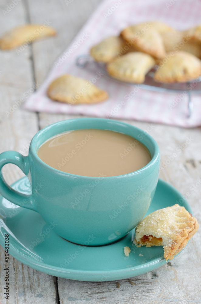 Cup of coffee with milk and apple pies on wooden background Cup of coffee with milk and apple pies on wooden background