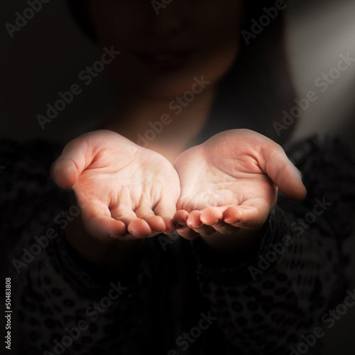 A woman holds a handful, hands together, asks