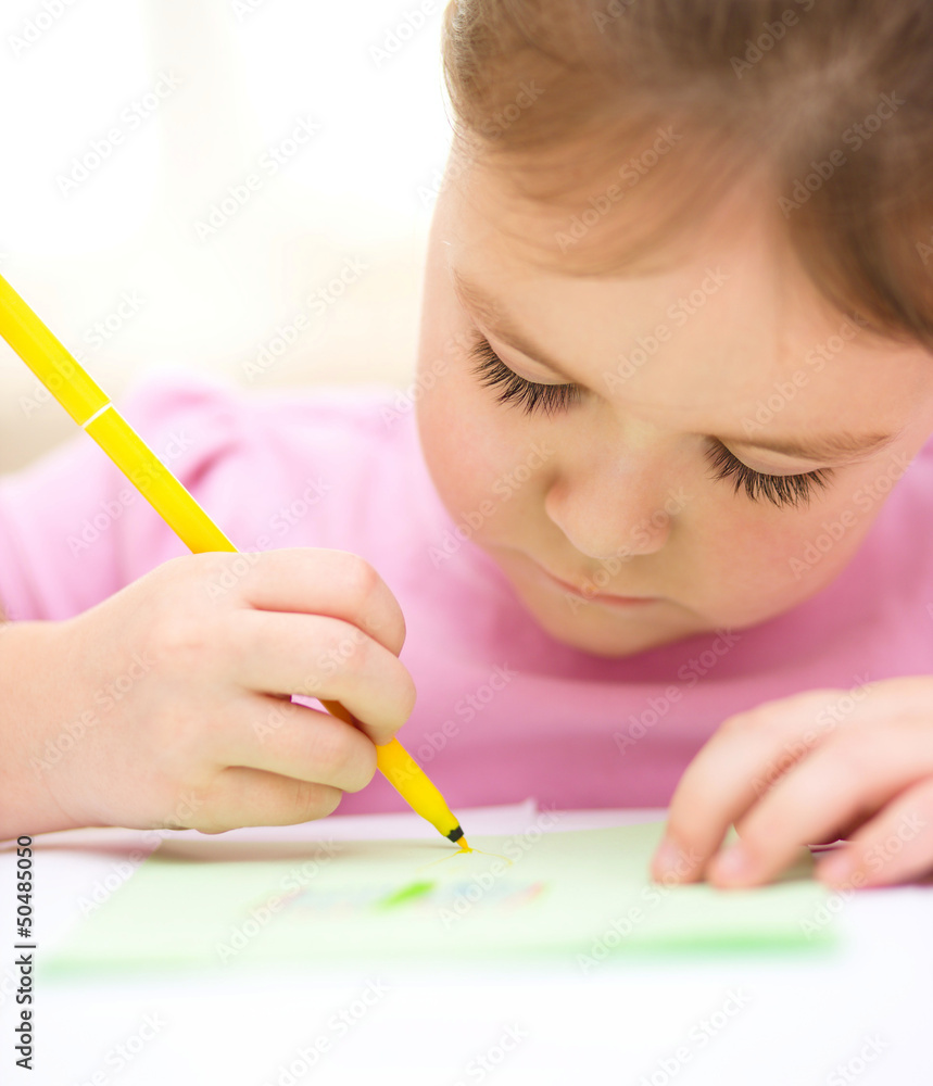 Cute cheerful child drawing using felt-tip pen Cute cheerful child drawing using felt-tip pen