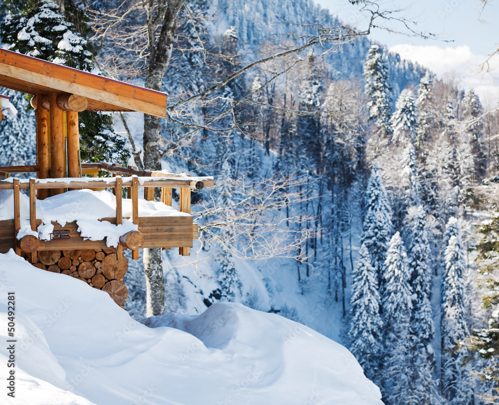 Obraz premium Wooden ski chalet in snow, mountain view