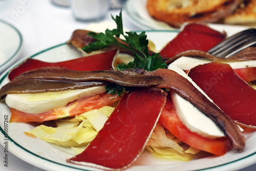 Ensalada de anchoas, mojama, queso y tomate photo