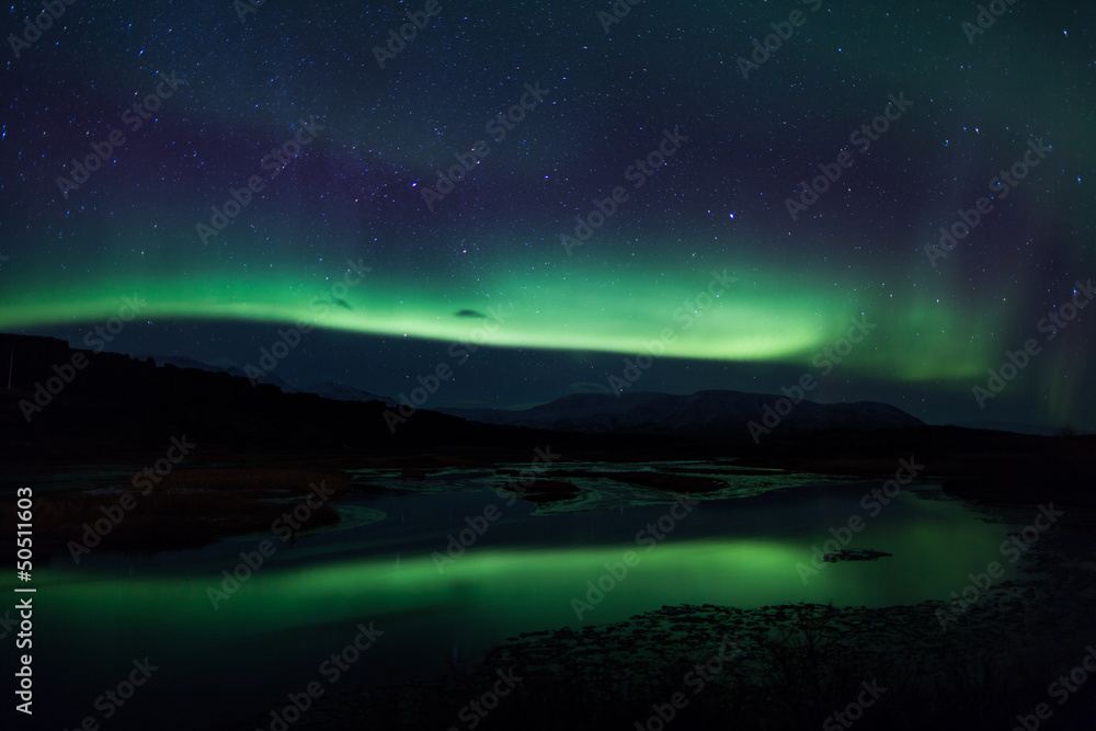 Northern lights above lagoon in Iceland