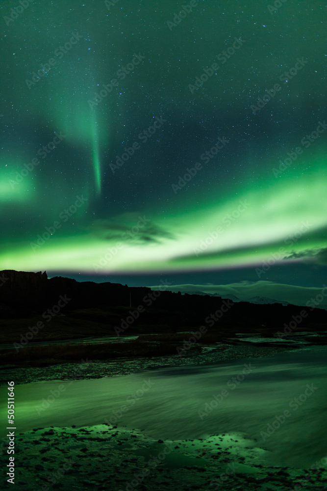 Northern lights above lagoon in Iceland