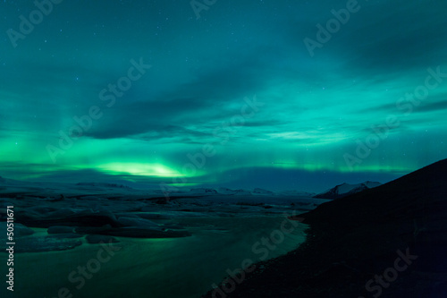 Northern lights above lagoon in Iceland © jamenpercy
