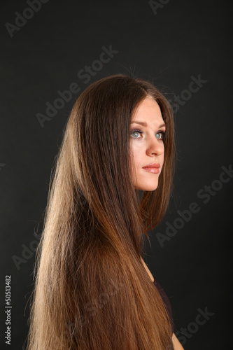 Portrait of beautiful woman with long hair on black background
