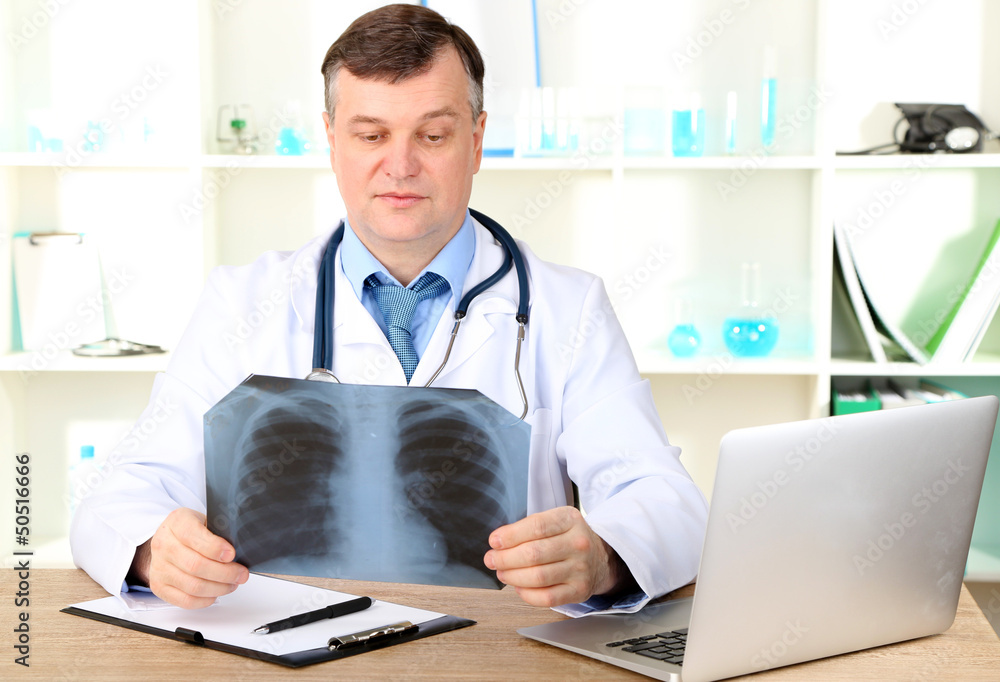 Medical doctor analysing x-ray image at desk Medical doctor analysing x-ray image at desk