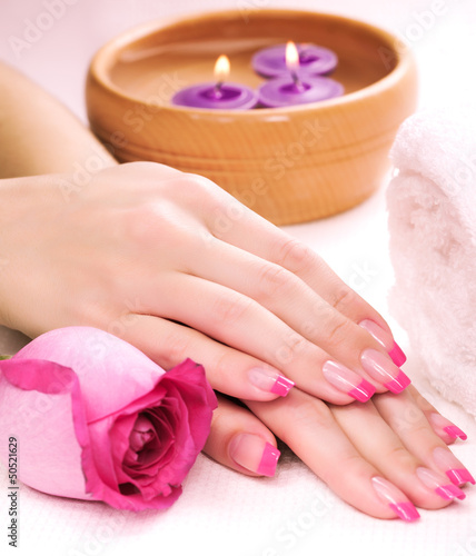 female hands with fragrant rose petals and towel. Spa