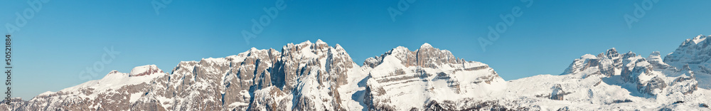 Panorama of winter snow mountain landscape with blue sky.