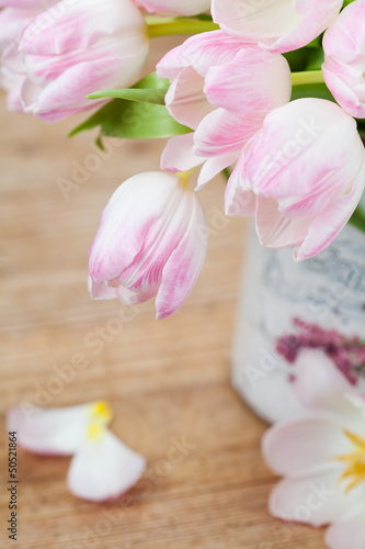 Bouquet of pink tulips in a vase on wooden background