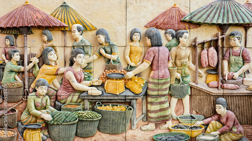 Stone carving of Thai rural fresh market on temple wall