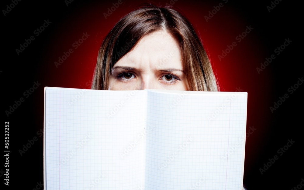 Disappointed and sad young girl holding exercise book Disappointed and sad young girl holding exercise book