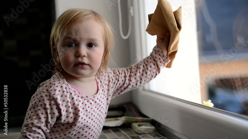 la jeune fille nettoyage la fenêtre