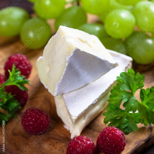 Soft french cheese with raspberries and grapes