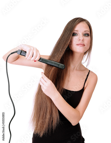 Woman doing hairstyle with hair straightener, isolated on white