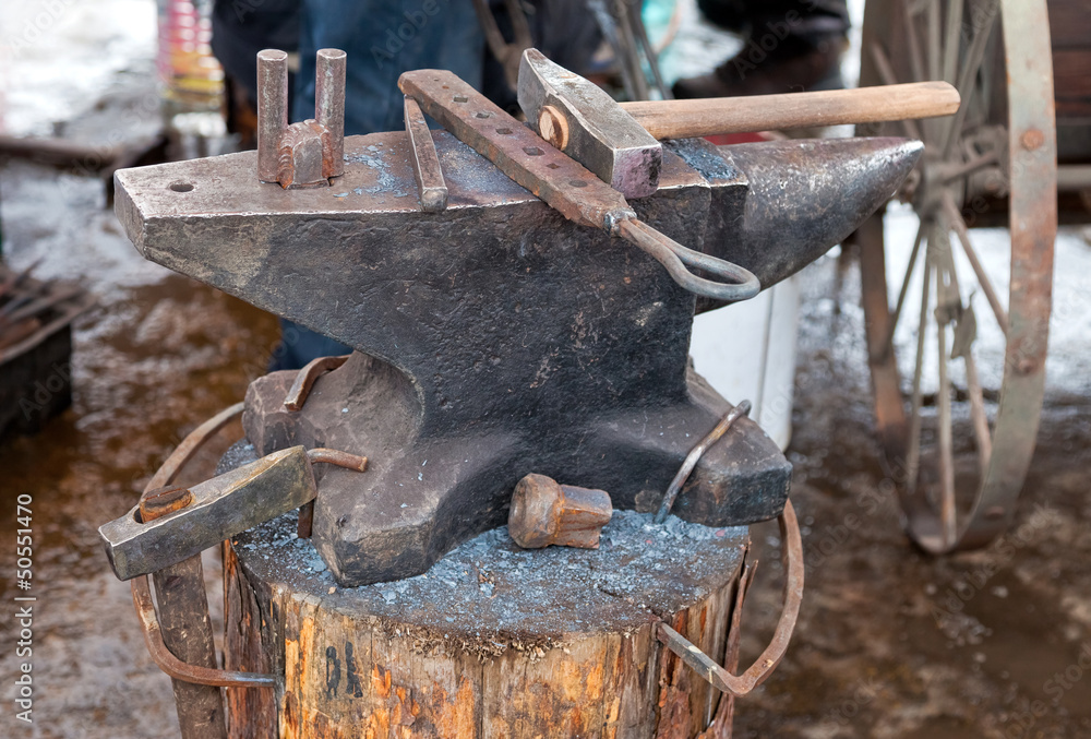 Old anvil with blacksmith tools on the outdoors Old anvil with blacksmith tools on the outdoors