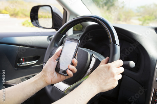 smart phone in hand while driving the car