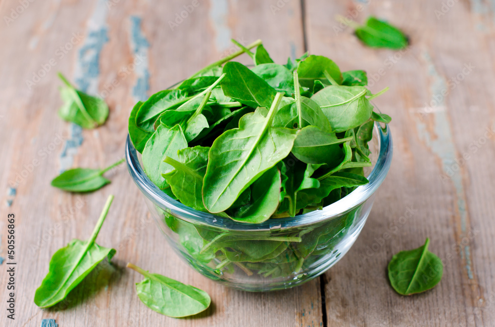 Spinach in a glass bowl on the table Spinach in a glass bowl on the table