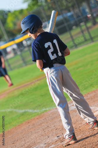 Teen baseball player getting ready to bat.
