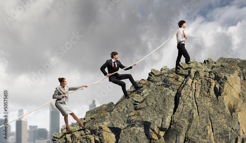 Three business people pulling rope