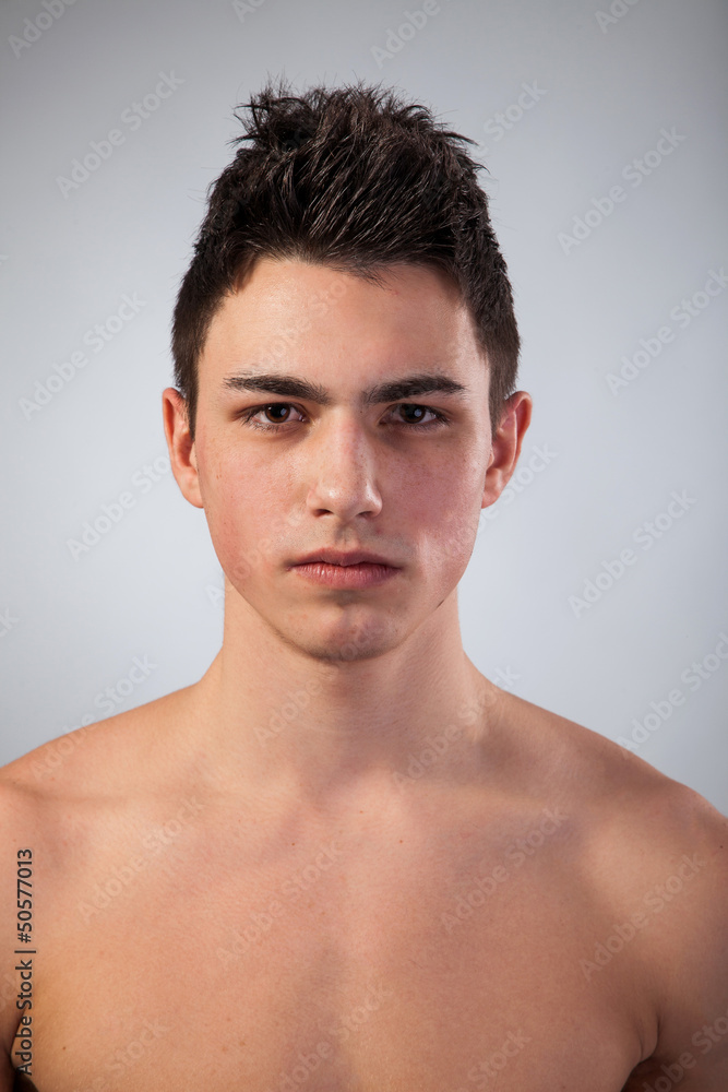 Handsome face of a young man on grey Handsome face of a young man on grey