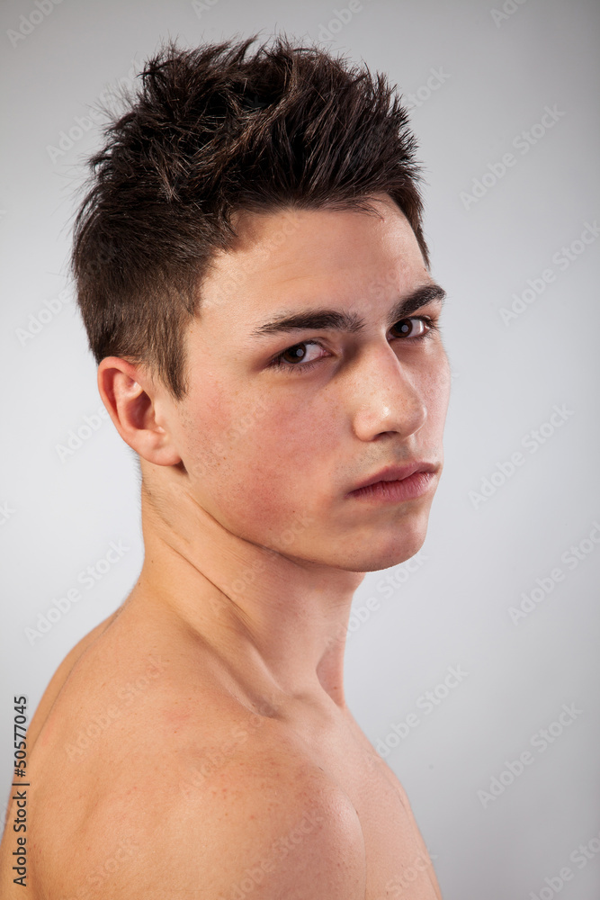 Handsome face of a young man on grey Handsome face of a young man on grey