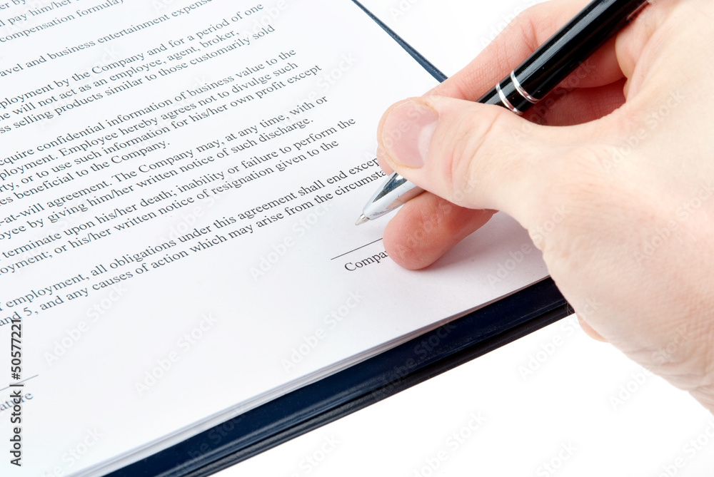 Hand with a pen signing an agreement Hand with a pen signing an agreement