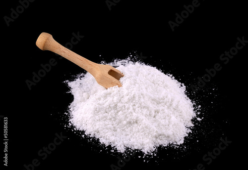 Sea salt with spoon isolated on black
