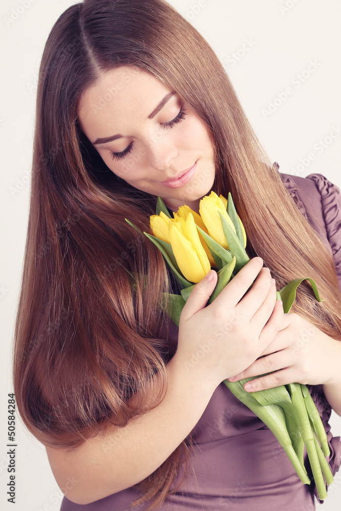 Beautiful woman with long hair with yellow tulips Beautiful woman with long hair with yellow tulips