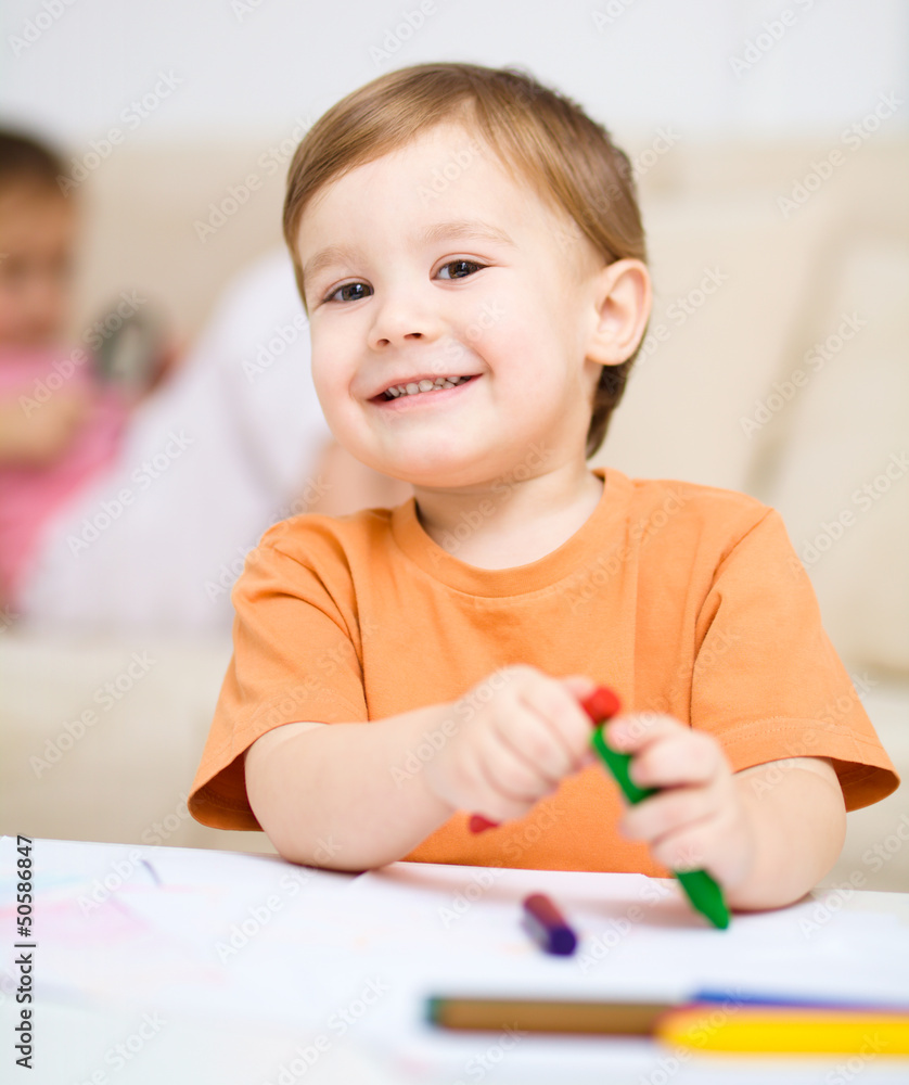 Little boy is drawing on white paper Little boy is drawing on white paper