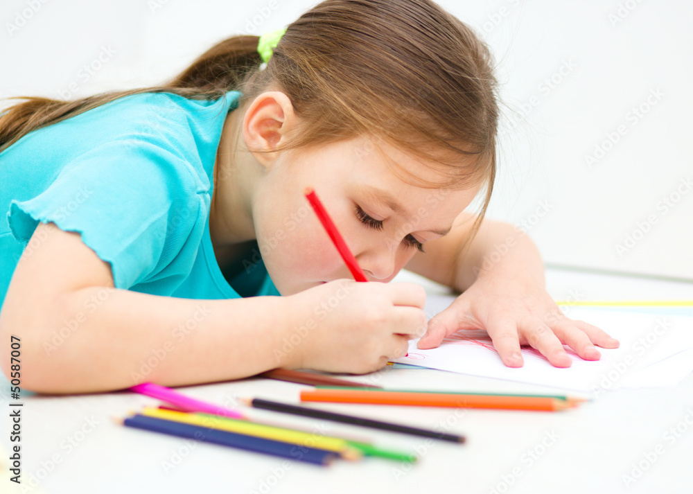 Little girl is drawing using pencils Little girl is drawing using pencils