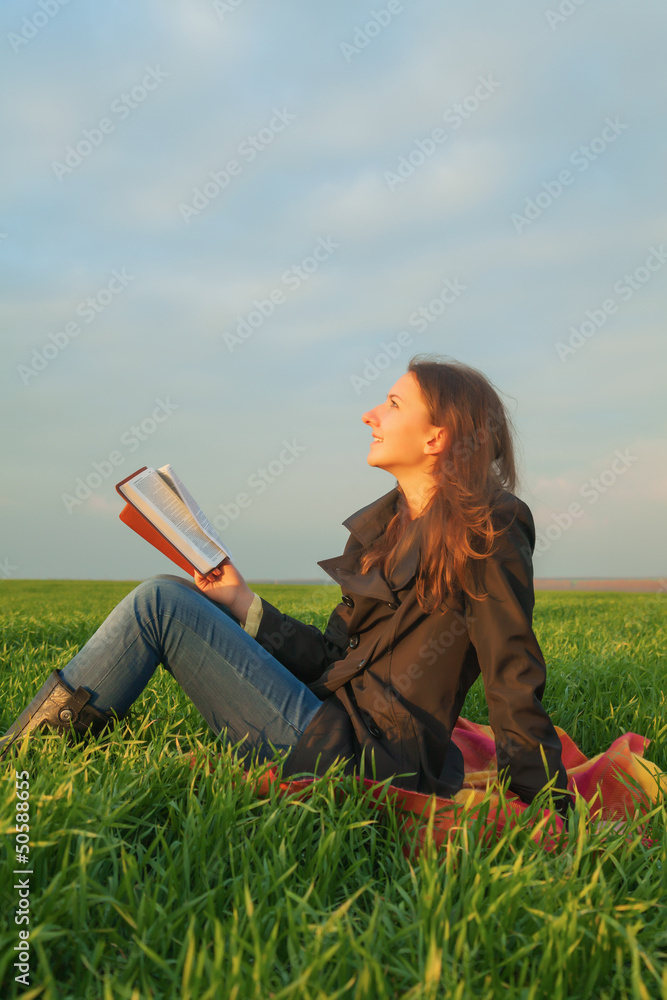 Teen girl reading the Bible outdoors