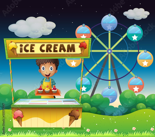 A boy with an icecream stall near the ferris wheel