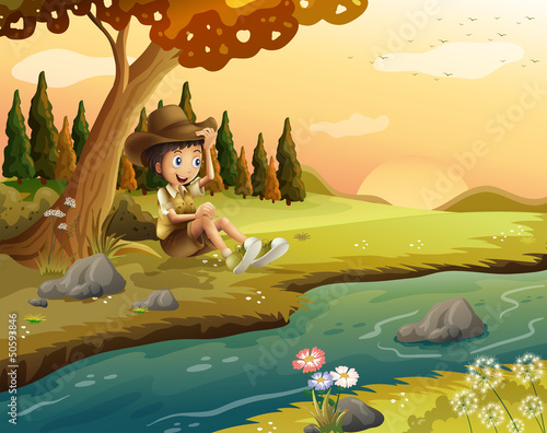 A boy sitting at the riverbank