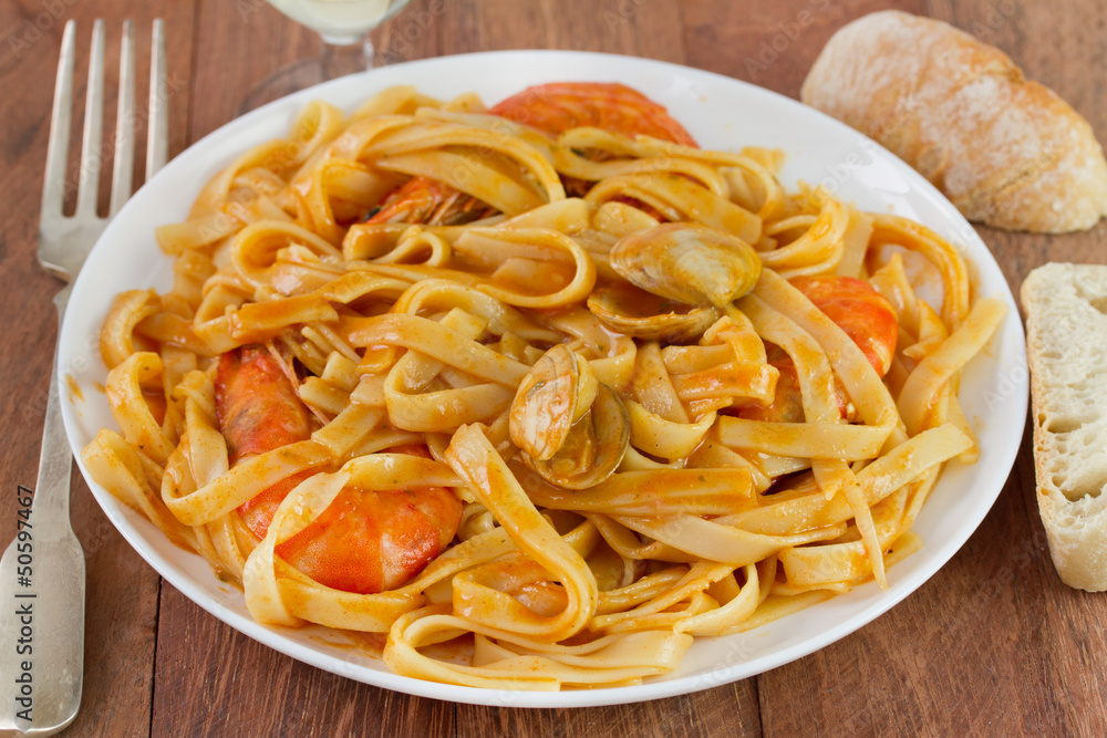 spaghetti with seafood on the white plate and bread