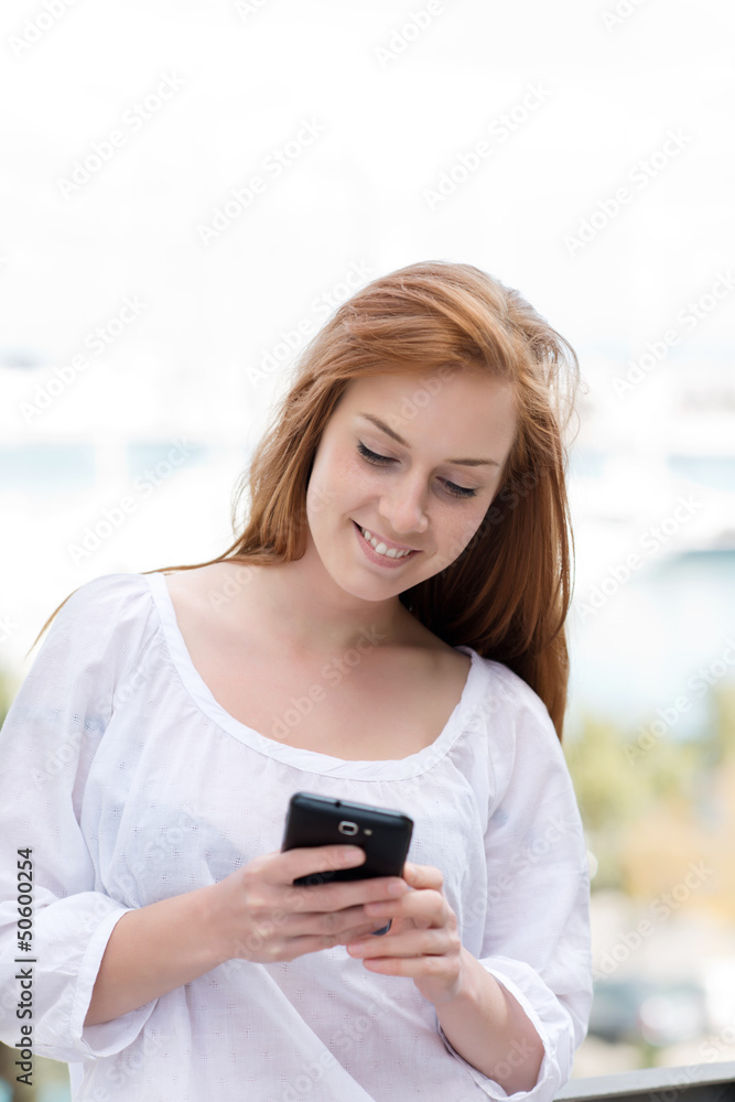 junge frau schaut auf ihr smartphone junge frau schaut auf ihr smartphone