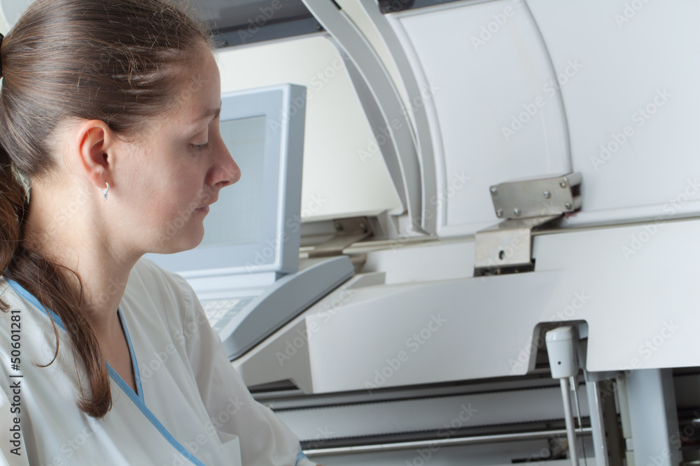 Woman loading samples in biochemical analyzer Woman loading samples in biochemical analyzer