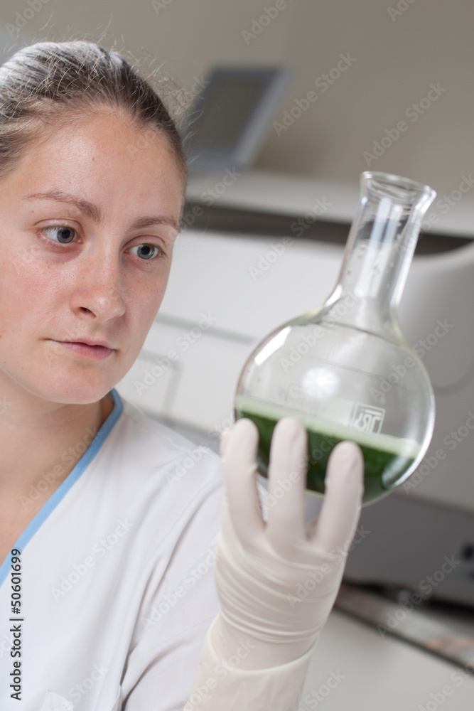 Woman examine colorful bottles fill with chemicals Woman examine colorful bottles fill with chemicals