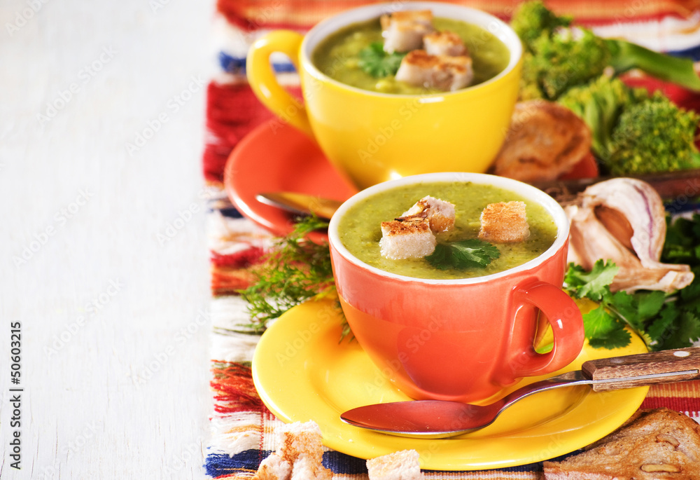 Two cheerful cup with green broccoli soup and dry toast Two cheerful cup with green broccoli soup and dry toast
