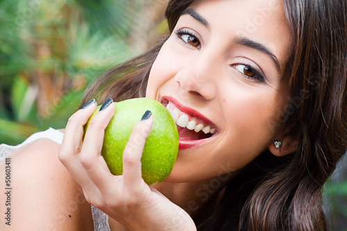 Portrait of a young woman's face eating an apple