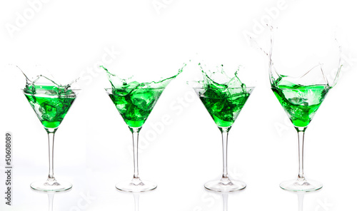 Serial arrangement of green liquid splashing in cocktail glass