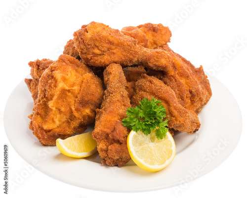 Ein ganzes Backhendl mit Zitrone und Petersilie auf einem weiße